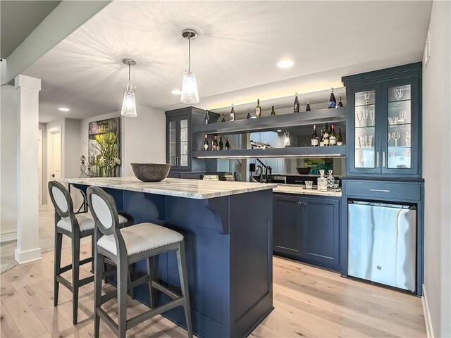 16724 Hayes St, Overland Park, KS 66085 - indoor wet bar featuring light wood-style floors, decorative columns, decorative light fixtures, baseboards, and recessed lighting