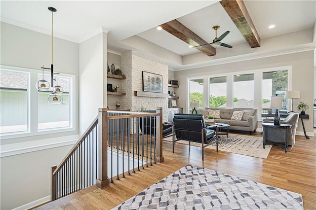 22018 W 114th Ct, Olathe, KS 66061 - living room featuring hardwood / wood-style flooring, a fireplace, ornamental molding, ceiling fan with notable chandelier, and beamed ceiling