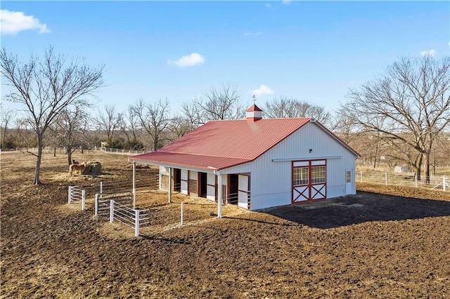 view of front of property with an outdoor structure and a rural view