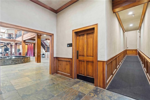 corridor featuring decorative columns, dark tile floors, and ornamental molding