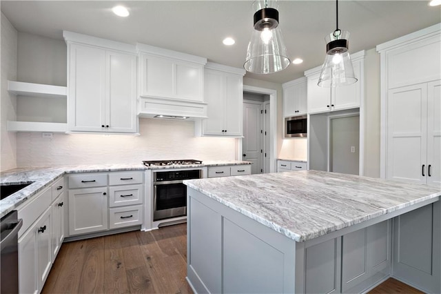 kitchen with dark hardwood / wood-style floors, tasteful backsplash, stainless steel appliances, and white cabinetry