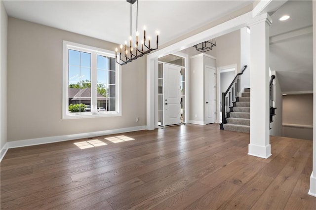 entryway with dark wood-type flooring and a chandelier