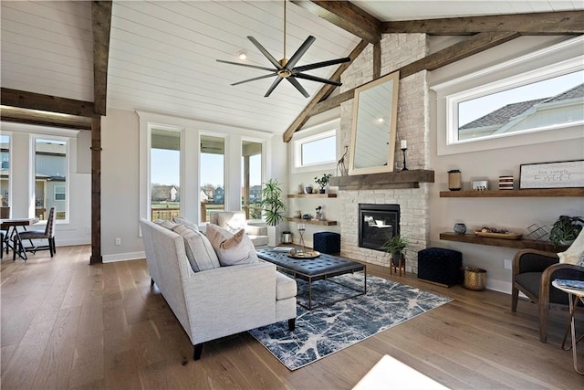 living room featuring plenty of natural light, dark hardwood / wood-style floors, ceiling fan, and a fireplace