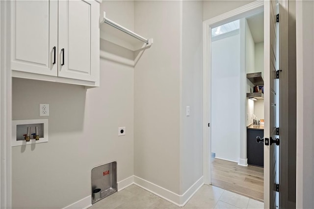 washroom with cabinets, hookup for an electric dryer, hookup for a washing machine, and light hardwood / wood-style flooring