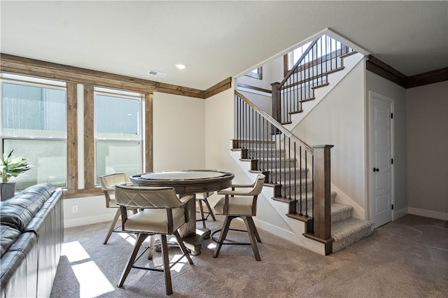 carpeted dining area featuring crown molding