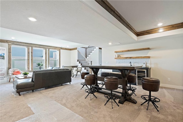 interior space featuring beverage cooler, indoor bar, and a tray ceiling