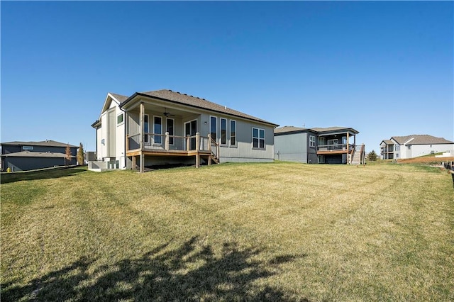 back of property with a wooden deck and a yard