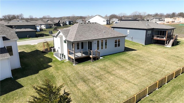 back of house with a deck and a lawn