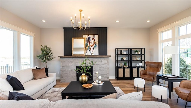 living room with light hardwood / wood-style floors, a chandelier, and a fireplace