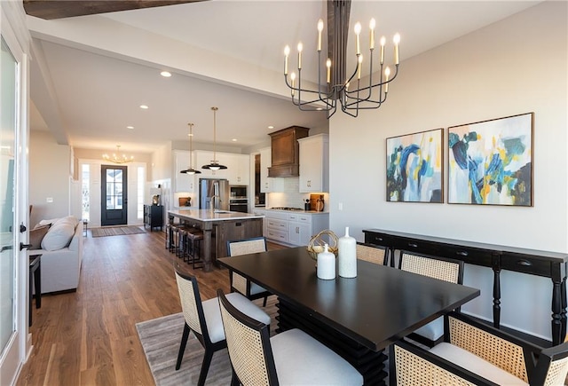 dining space with an inviting chandelier, french doors, beam ceiling, and hardwood / wood-style flooring