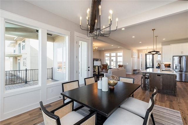 dining area with beamed ceiling, dark hardwood / wood-style floors, and sink