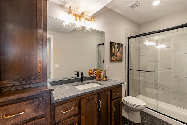 bathroom featuring toilet, a shower with shower door, a textured ceiling, and vanity