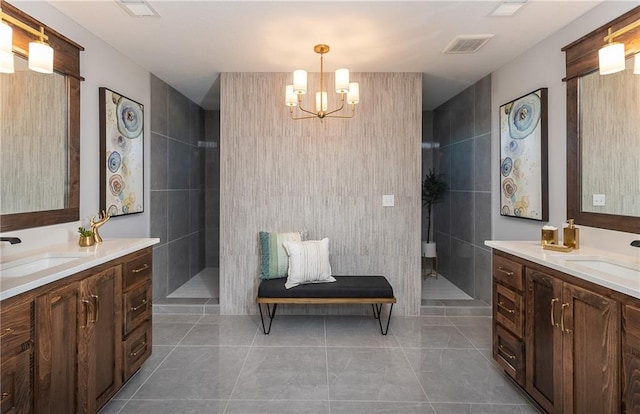 bathroom with tile walls, vanity, a notable chandelier, and tiled shower