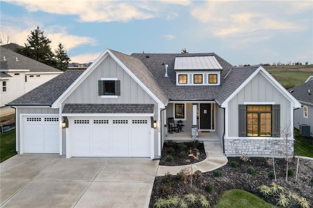 view of front facade featuring covered porch, central AC unit, and a garage