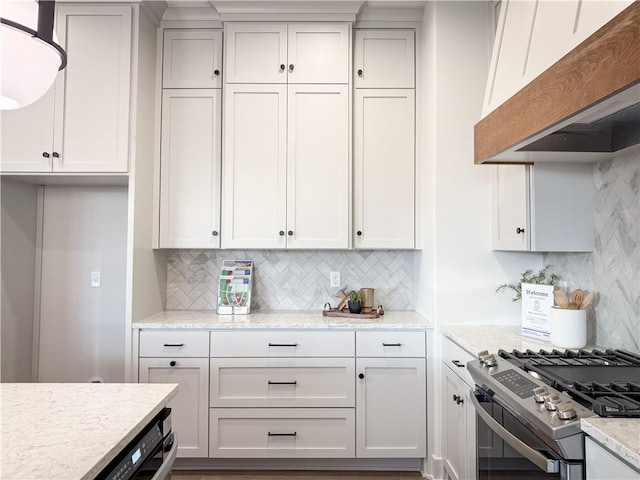 kitchen with decorative backsplash, white cabinetry, light stone countertops, and stainless steel range with gas stovetop