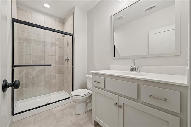 bathroom featuring tile patterned floors, vanity, toilet, and walk in shower