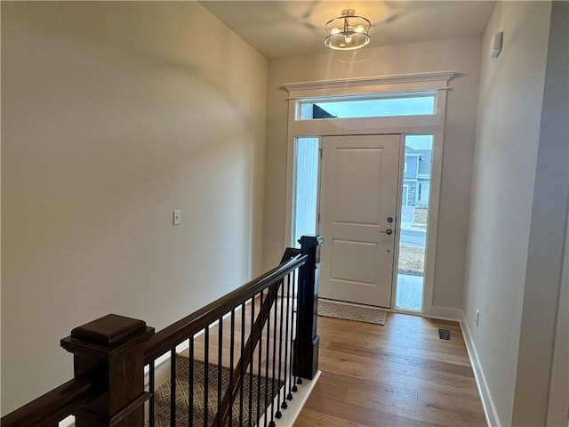 foyer entrance featuring light hardwood / wood-style flooring and an inviting chandelier