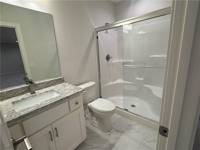 bathroom with vanity, toilet, and a shower with door