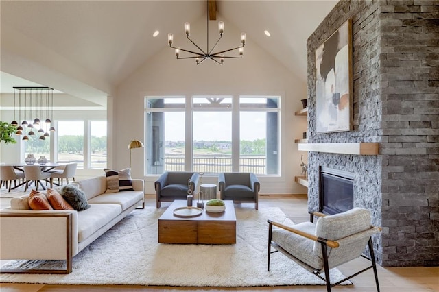 living room with a chandelier, high vaulted ceiling, a fireplace, beam ceiling, and light wood finished floors