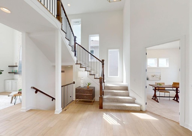 16743 S Hall St, Olathe, KS 66062 - stairs featuring wood finished floors, a towering ceiling, baseboards, and recessed lighting