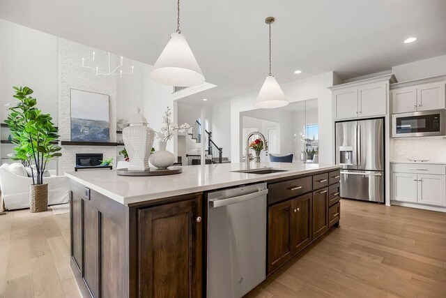 16743 S Hall St, Olathe, KS 66062 - kitchen featuring light wood-type flooring, white cabinetry, appliances with stainless steel finishes, light countertops, and a sink