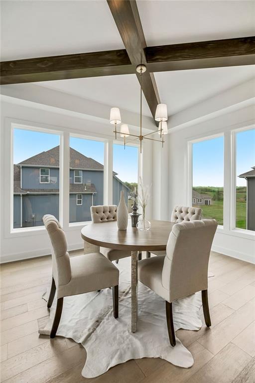 16743 S Hall St, Olathe, KS 66062 - dining room featuring light wood-type flooring, a healthy amount of sunlight, and an inviting chandelier