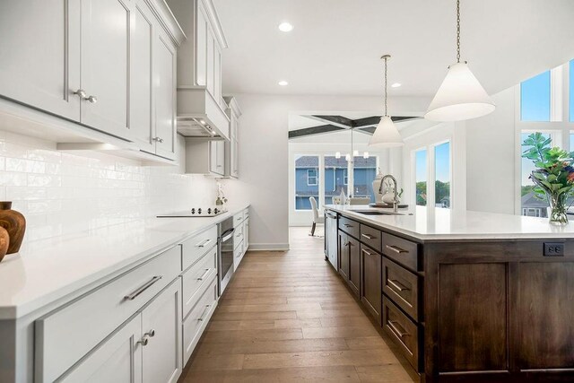 16743 S Hall St, Olathe, KS 66062 - kitchen with light countertops, dark brown cabinets, appliances with stainless steel finishes, decorative backsplash, and a sink