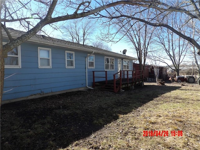 rear view of property with a yard and a wooden deck