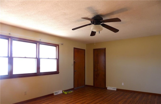 empty room featuring ceiling fan, dark hardwood / wood-style floors, and a textured ceiling