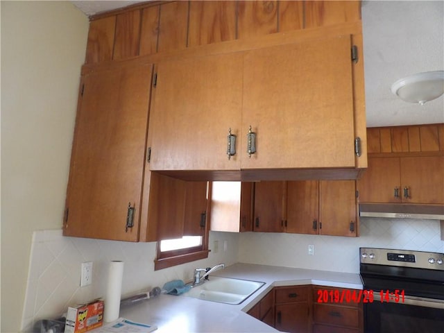 kitchen featuring electric stove, tasteful backsplash, and sink