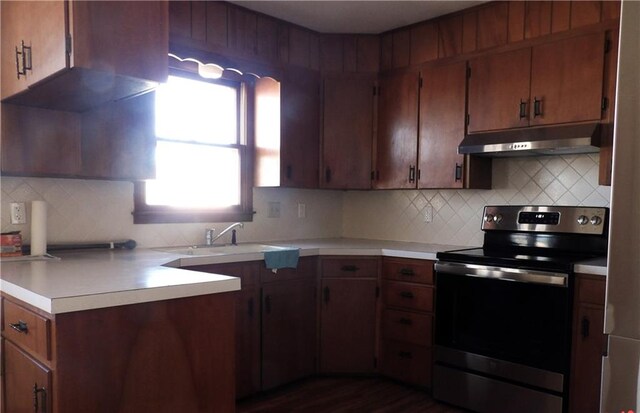 kitchen with backsplash, dark wood-type flooring, electric range, and sink