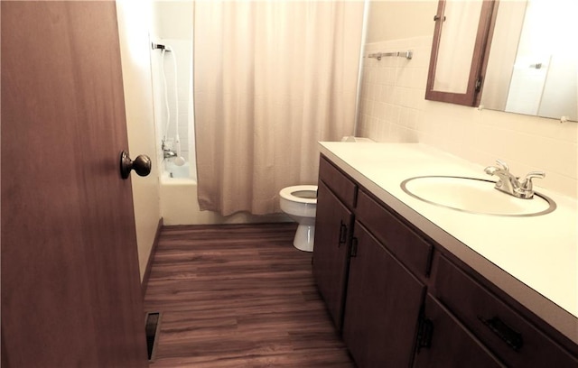 full bathroom featuring vanity, toilet, hardwood / wood-style flooring, and shower / bath combo with shower curtain