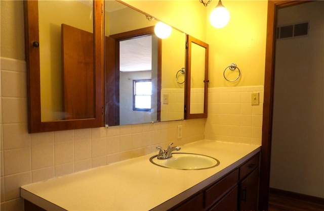 bathroom with backsplash, vanity, and tile walls