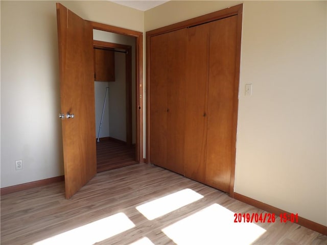 unfurnished bedroom with light hardwood / wood-style floors and a closet