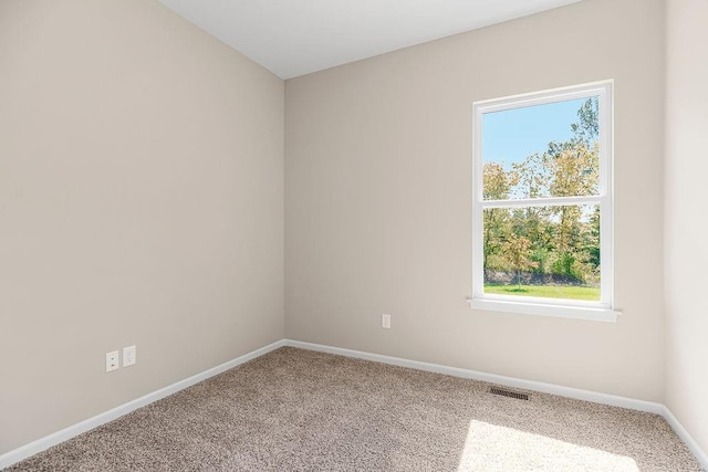 carpeted empty room with visible vents and baseboards