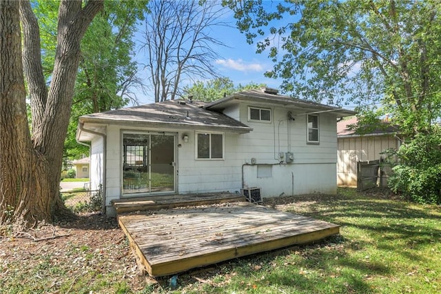 back of property with a deck and a lawn