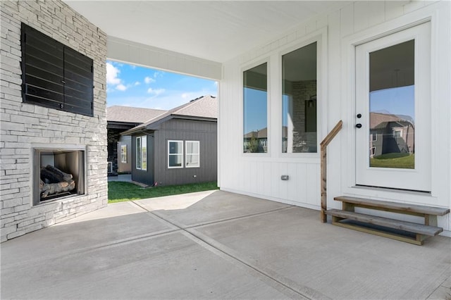 view of terrace featuring an outdoor stone fireplace