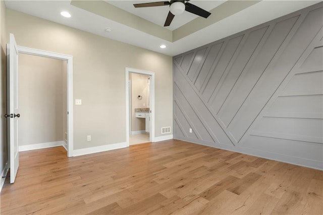 unfurnished bedroom featuring ceiling fan, light hardwood / wood-style floors, and connected bathroom