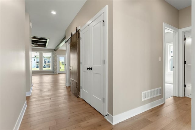 hall featuring light hardwood / wood-style floors and a barn door