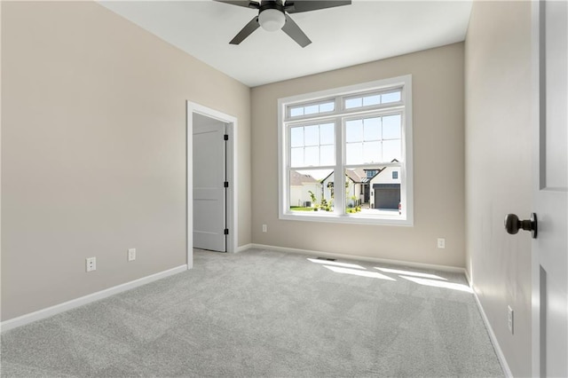 carpeted spare room featuring ceiling fan