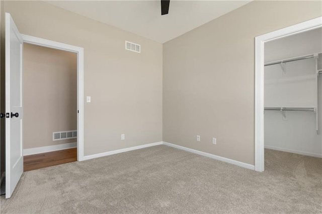 unfurnished bedroom with carpet, ceiling fan, and a closet