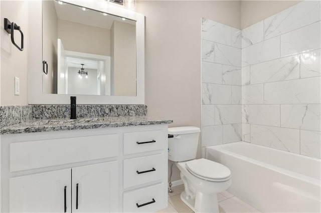 full bathroom featuring tiled shower / bath, toilet, tile floors, and large vanity