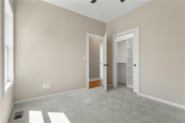 unfurnished bedroom with a closet, ceiling fan, and carpet floors