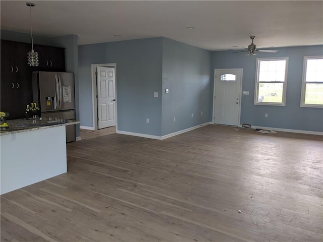 unfurnished living room featuring ceiling fan and hardwood / wood-style floors