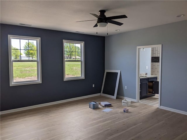 unfurnished room with light wood-type flooring and ceiling fan