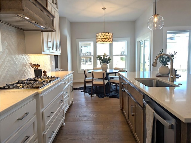 kitchen featuring sink, tasteful backsplash, appliances with stainless steel finishes, custom range hood, and white cabinets