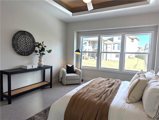 bedroom featuring carpet floors, a raised ceiling, and ceiling fan