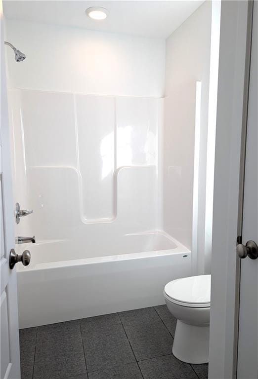 bathroom featuring tile patterned floors, toilet, and bathtub / shower combination