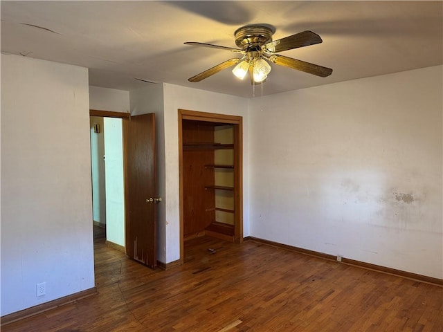 empty room with ceiling fan, baseboards, and wood finished floors