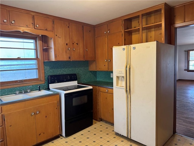 kitchen featuring electric stove, a sink, open shelves, white fridge with ice dispenser, and light floors